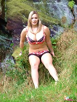 Busty British babe H Cup Holly teases and strips outdoors on the moors.